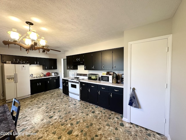 kitchen with a textured ceiling, white appliances, decorative light fixtures, and sink