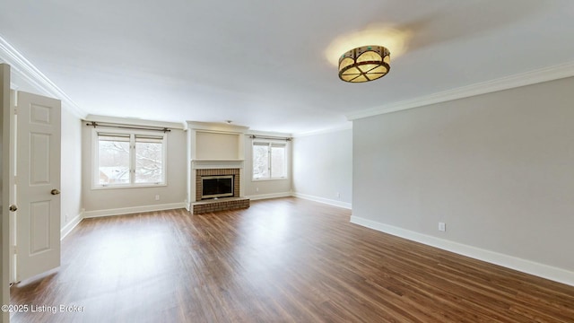 unfurnished living room featuring a brick fireplace, ornamental molding, and hardwood / wood-style flooring