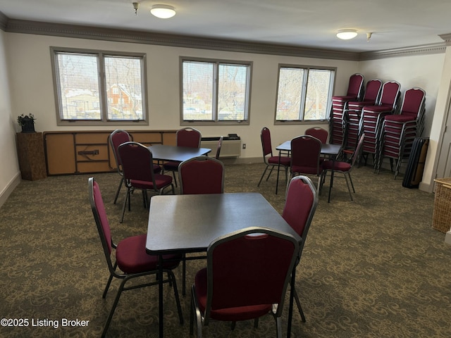 dining space featuring crown molding and dark colored carpet