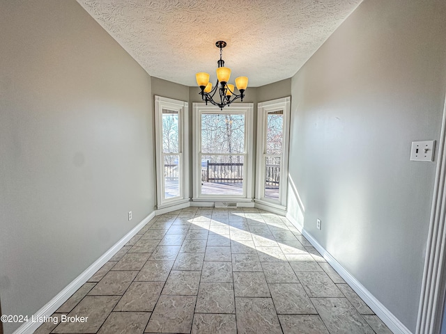 interior space featuring a textured ceiling and a notable chandelier