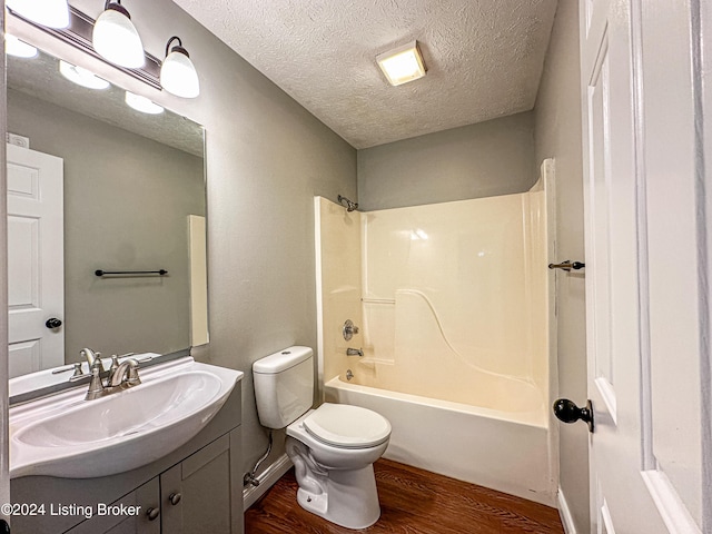 full bathroom featuring vanity, tub / shower combination, a textured ceiling, and hardwood / wood-style flooring