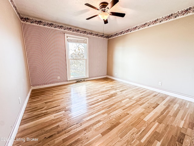 unfurnished room with hardwood / wood-style flooring, ceiling fan, and a textured ceiling