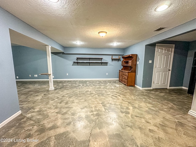 basement featuring carpet floors and a textured ceiling