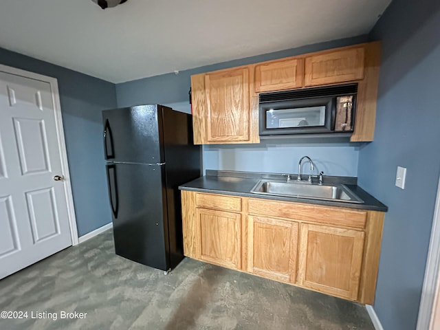 kitchen featuring black fridge and sink