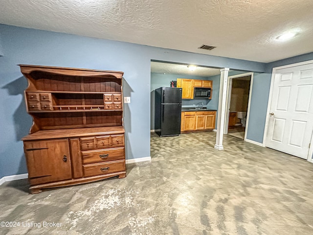 kitchen featuring black appliances, sink, and a textured ceiling