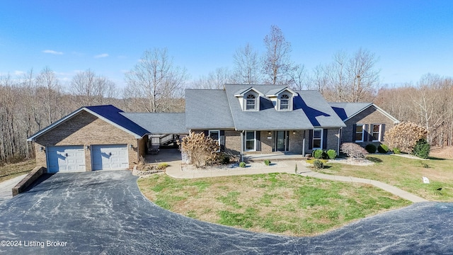 new england style home featuring a front yard and a garage