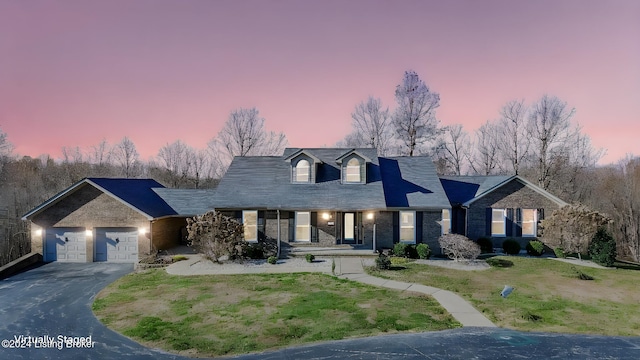 cape cod-style house with a lawn and a garage