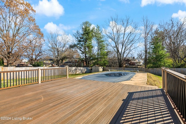 wooden deck with a shed and a covered pool