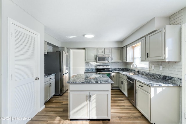 kitchen with a center island, dark hardwood / wood-style flooring, sink, and appliances with stainless steel finishes