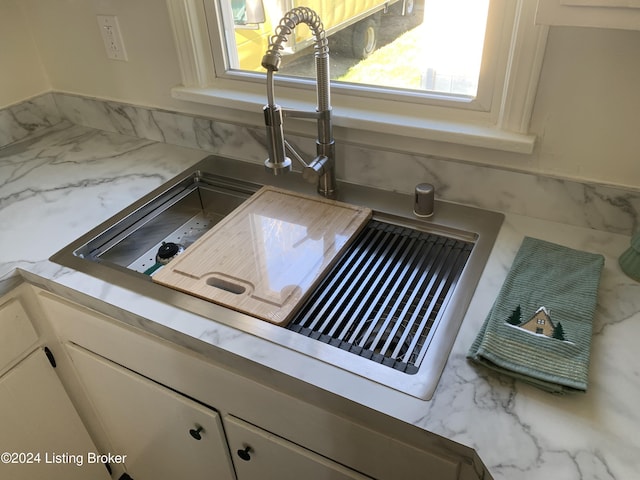 details featuring white cabinets and sink