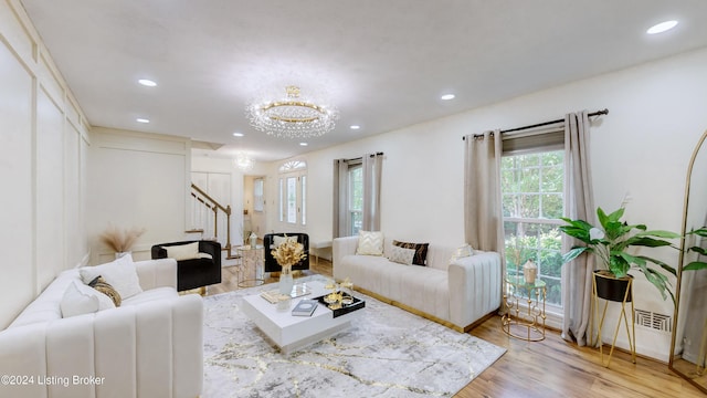 living room with light hardwood / wood-style floors and an inviting chandelier