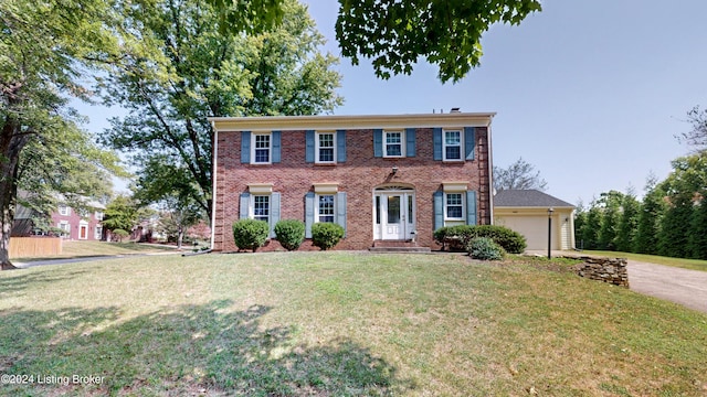 colonial house with a front lawn and a garage