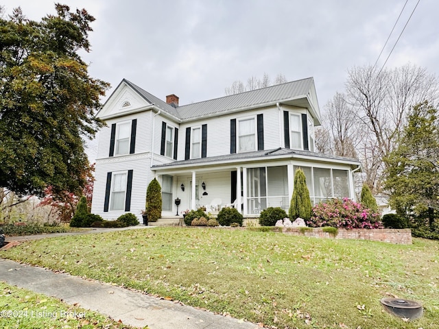 205 W Chestnut St, Leitchfield, KY 42754 - view of front of house featuring a chimney, a front yard, a sunroom, and a metal roof