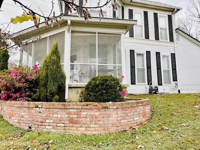 view of property exterior with a sunroom and a yard