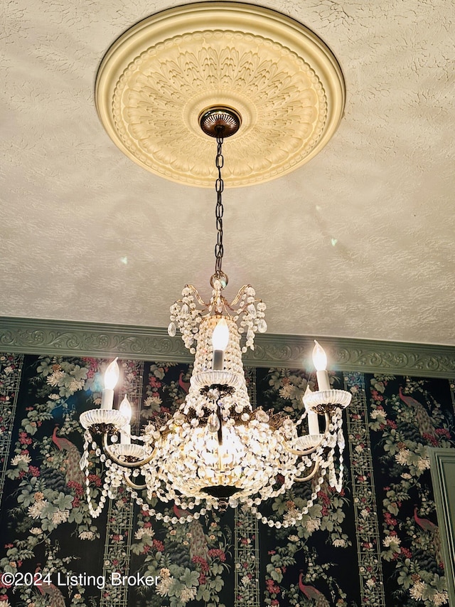 details with a textured ceiling and a chandelier