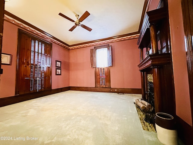 carpeted empty room with ceiling fan and ornamental molding