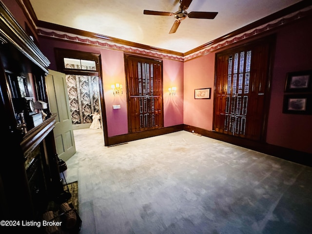 carpeted empty room with ceiling fan and ornamental molding