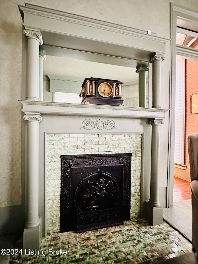 room details featuring a tile fireplace and wood-type flooring