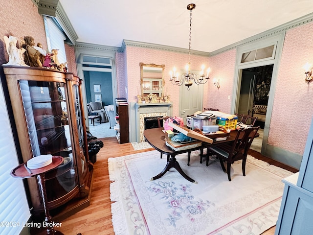205 W Chestnut St, Leitchfield, KY 42754 - dining area featuring a chandelier, light wood finished floors, crown molding, wallpapered walls, and a fireplace with flush hearth