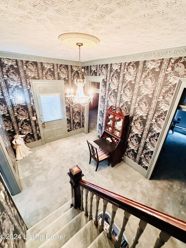 stairway with carpet floors, a textured ceiling, and an inviting chandelier