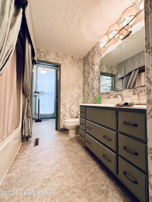 full bathroom with vanity, toilet, washtub / shower combination, and a textured ceiling