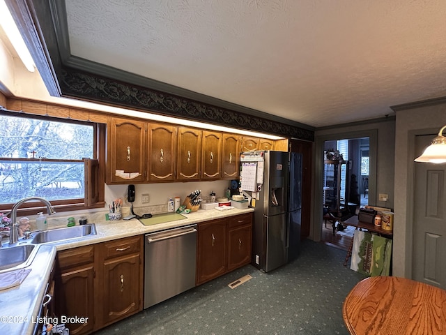 kitchen with crown molding, sink, a textured ceiling, and appliances with stainless steel finishes