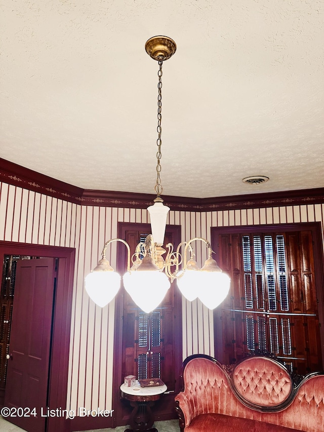 sitting room with ornamental molding and a textured ceiling