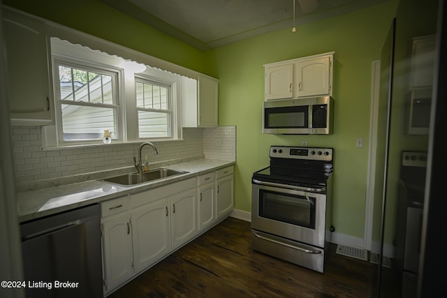 kitchen with decorative backsplash, stainless steel appliances, white cabinetry, and sink