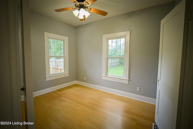 spare room with light hardwood / wood-style flooring, a wealth of natural light, and ceiling fan