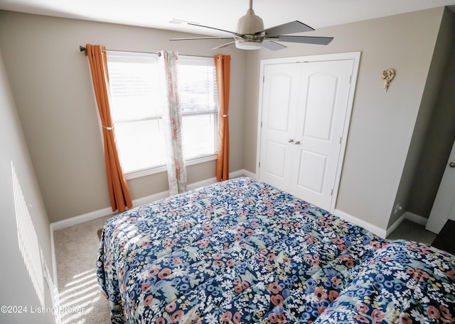 carpeted bedroom with ceiling fan and a closet