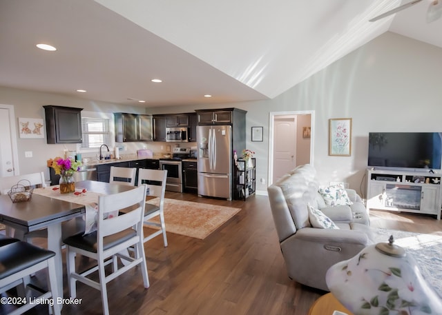 dining room with dark hardwood / wood-style flooring, vaulted ceiling, and sink