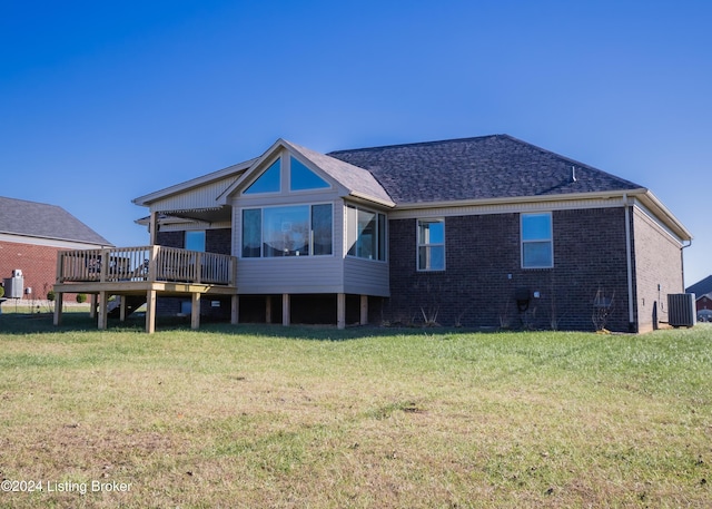 back of house with a lawn, a wooden deck, a sunroom, and central AC