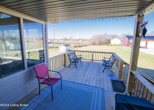 wooden deck featuring a storage unit and a yard