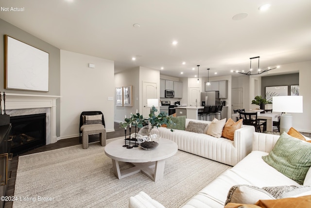 living room featuring a fireplace, an inviting chandelier, and light hardwood / wood-style flooring