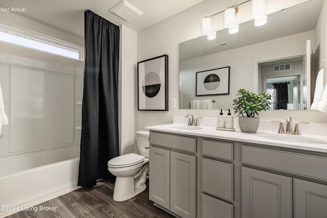 full bathroom featuring shower / bathtub combination with curtain, hardwood / wood-style floors, vanity, and toilet