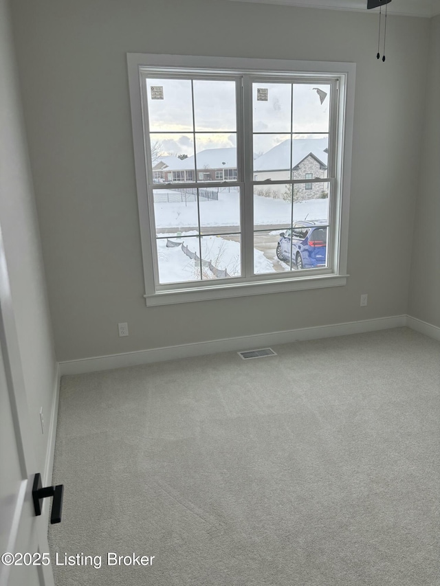 spare room featuring carpet, visible vents, and baseboards