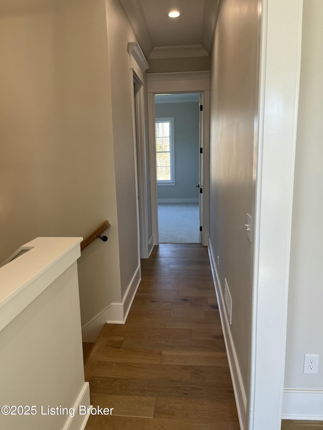 hall featuring visible vents, ornamental molding, an upstairs landing, wood finished floors, and baseboards