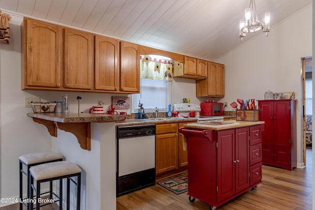 kitchen featuring a kitchen bar, pendant lighting, light hardwood / wood-style floors, and white appliances