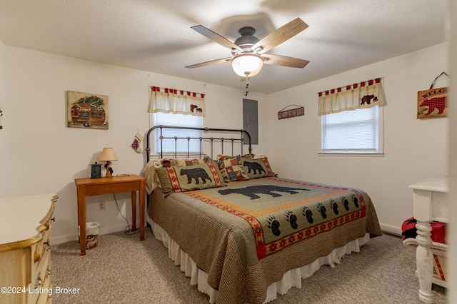 carpeted bedroom with ceiling fan, a textured ceiling, and multiple windows