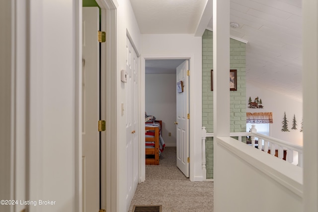 corridor with light carpet and vaulted ceiling