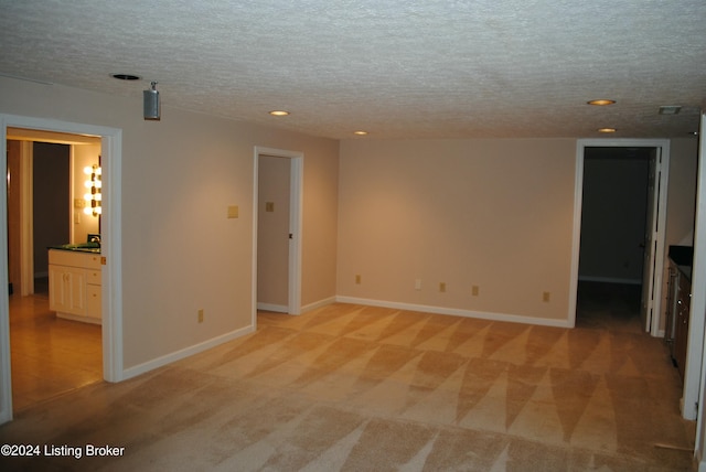 carpeted spare room with a textured ceiling