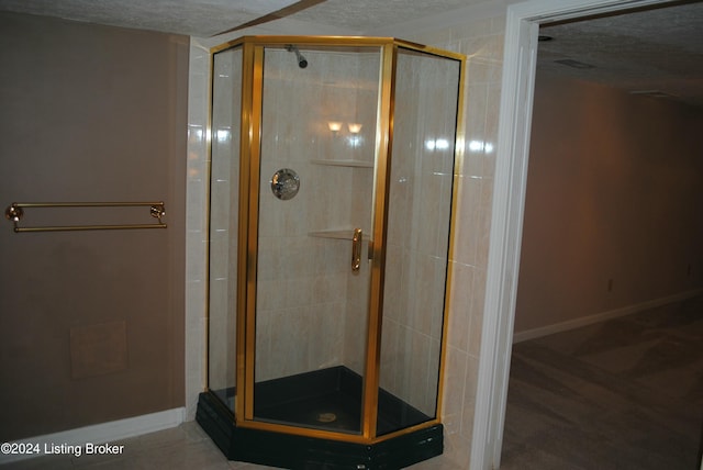 bathroom with a shower with shower door and a textured ceiling