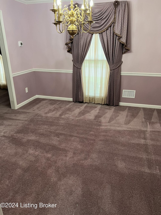 carpeted spare room featuring a chandelier and crown molding