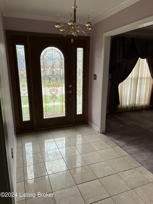 carpeted entrance foyer featuring crown molding, a healthy amount of sunlight, and a notable chandelier