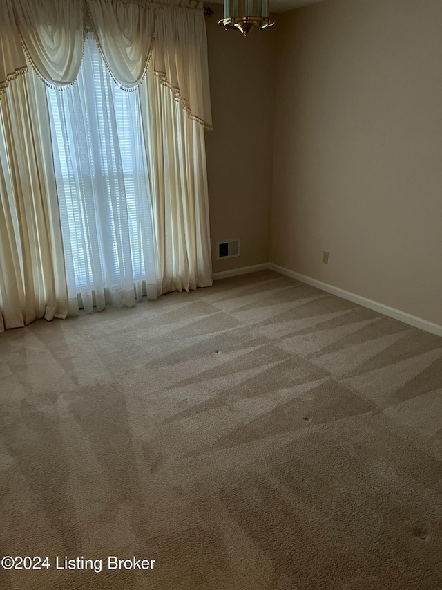 unfurnished room featuring light carpet