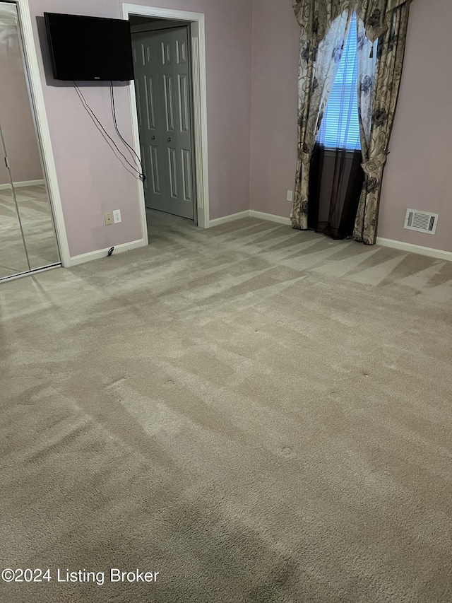 spare room featuring light carpet