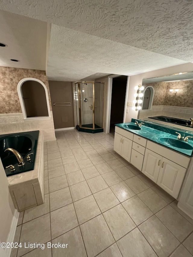 bathroom featuring tile patterned floors, vanity, separate shower and tub, and a textured ceiling