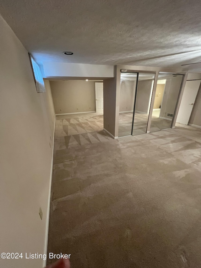 basement with carpet and a textured ceiling