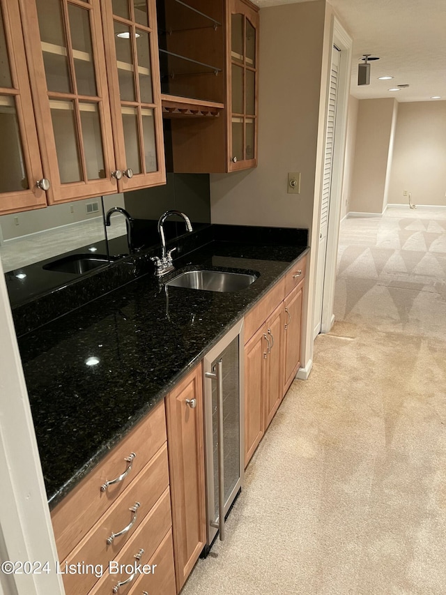 kitchen with wine cooler, sink, light carpet, and dark stone counters