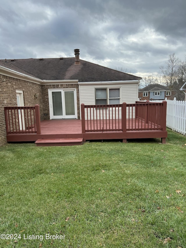 rear view of house with a yard and a wooden deck